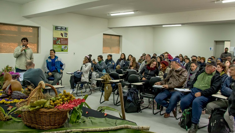 Imagem mostra público reunido, assistindo à apresentação de um dos palestrantes do evento