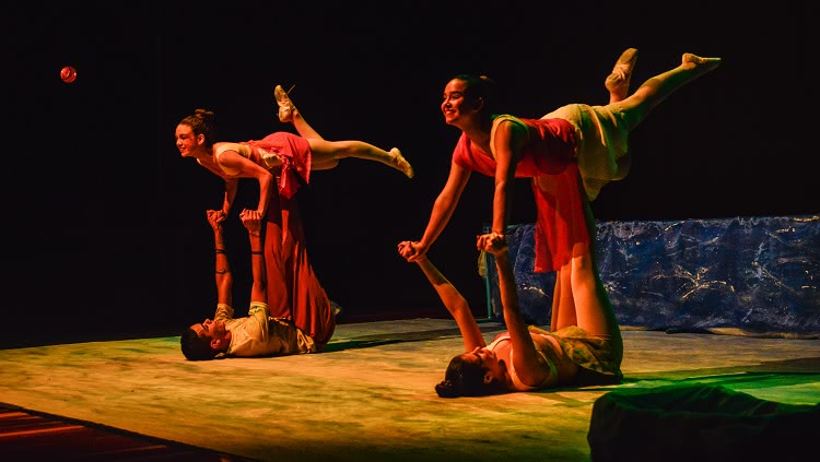 Imagem mostra dois bailarinos, de costas para o chão, segurando no alto de seus braços outras duas dançarinas