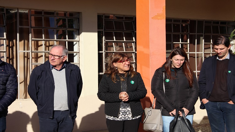 A foto mostra grupo de pessoas em pé, lado a lado.