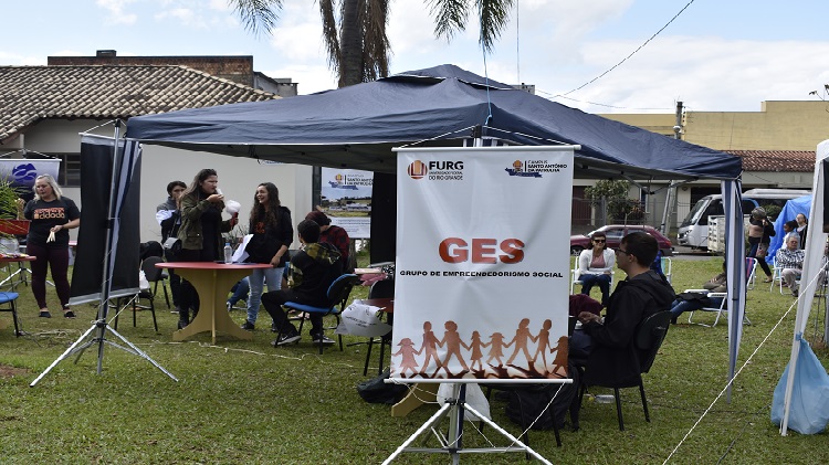 A imagem mostra uma tenda com o banner do Grupo Gese da FURG.