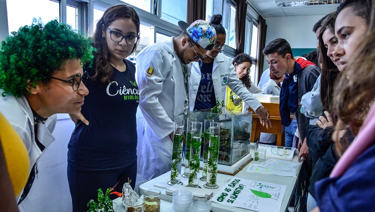 Imagem mostra estudantes da universidade apresentando equipamentos de laboratório