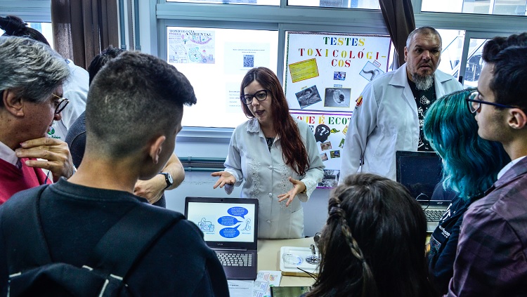 Imagem mostra estudantes da universidade apresentando equipamentos de laboratório