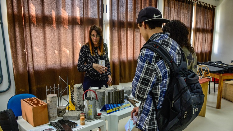 Imagem mostra estudantes da universidade apresentando equipamentos de laboratório