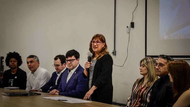 Imagem mostra mesa de abertura, com destaque para a pessoa da Reitora Cleuza Maria Sobral Dias