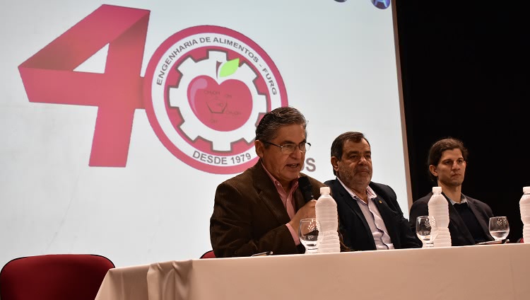 Imagem mostra pessoas compondo a mesa de abertura do evento