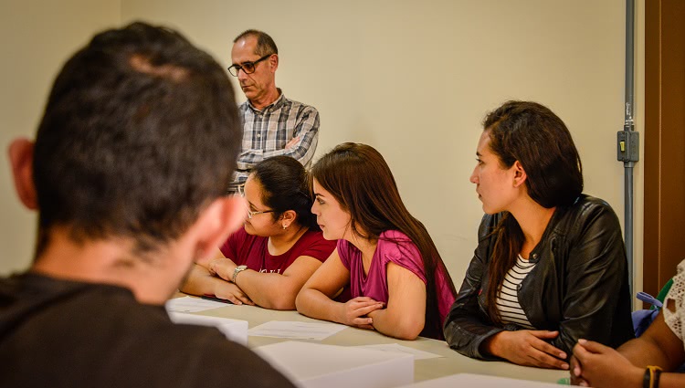 Imagem destaca estudantes reunidos ao redor de uma mesa