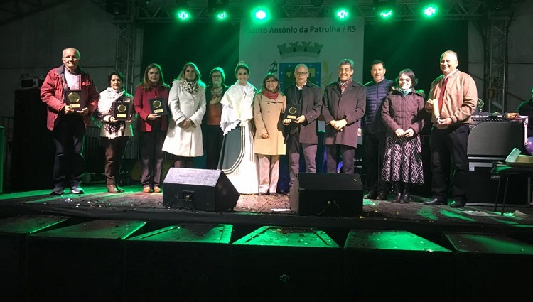 Os homenageados enfileirados lado a lado em cima do palco