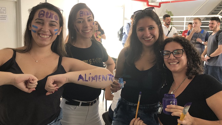 Meninas lado a lado posando para foto com partes do rosto e braços pintados