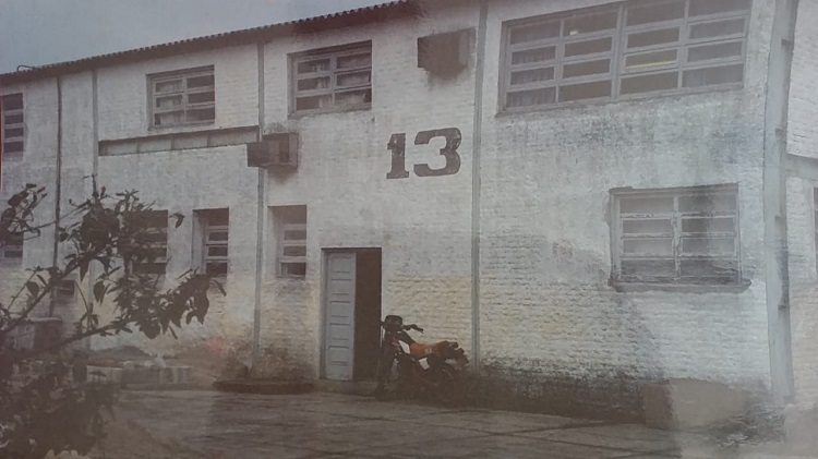 Imagem em preto e branco, mostra fachada de um prédio com o número 13