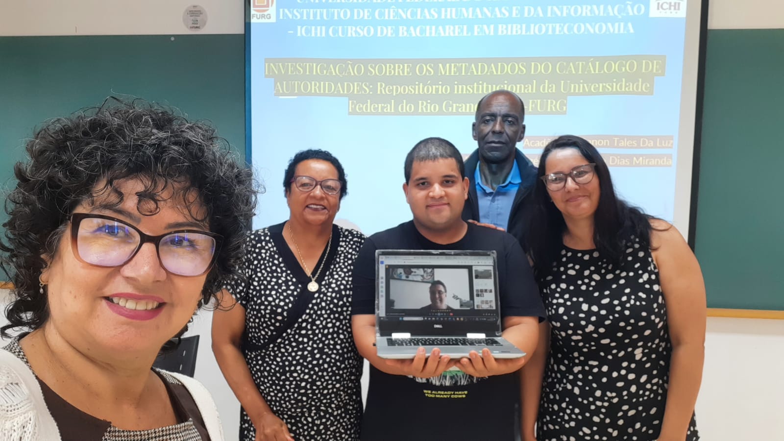 Estudante de Biblioteconomia ao lado de sua família e de sua banca avaliadora do TCC.